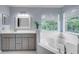 Bright bathroom with a tub, shower, and vanity with natural light at 4445 Blue Major Dr, Windermere, FL 34786