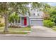 Charming two-story home with a well-manicured lawn, red front door, and an attached two-car garage at 4445 Blue Major Dr, Windermere, FL 34786