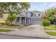 Charming two-story home with a well-manicured lawn, red front door, and an attached two-car garage at 4445 Blue Major Dr, Windermere, FL 34786