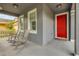 Inviting covered front porch with two rocking chairs and a vibrant red front door at 4445 Blue Major Dr, Windermere, FL 34786