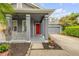 Inviting front porch with classic columns and view of a vibrant red front door and landscaped yard at 4445 Blue Major Dr, Windermere, FL 34786