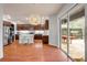 Bright kitchen with wood floors, stainless appliances, wood cabinets, island seating, and an adjacent dining space with patio access at 4445 Blue Major Dr, Windermere, FL 34786