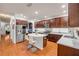 Bright kitchen features wood floors, cabinets, stainless appliances, granite counters and a large center island with seating at 4445 Blue Major Dr, Windermere, FL 34786