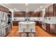 Spacious kitchen features wood floors, stainless appliances, white counters, wood cabinets and a large center island with seating at 4445 Blue Major Dr, Windermere, FL 34786
