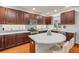 Kitchen with wood cabinets, stainless appliances, light counters, glass brick backsplash, and large island at 4445 Blue Major Dr, Windermere, FL 34786