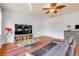 Living room with a ceiling fan, a large television, wood floors, and bright windows that let in ample natural light at 4445 Blue Major Dr, Windermere, FL 34786