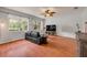 Living room featuring wood floors, a ceiling fan, a television, and a large window with natural light at 4445 Blue Major Dr, Windermere, FL 34786