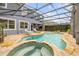 A charming screened-in pool featuring a hot tub, with a lovely view of the home's exterior at 4445 Blue Major Dr, Windermere, FL 34786