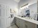 Bright bathroom featuring a double sink vanity with stone countertop, framed mirror, and accent lighting at 4521 Eaglewood Dr, Leesburg, FL 34748