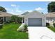 Charming single-story home featuring a well-manicured lawn, flowerbeds, and a two-car garage at 4521 Eaglewood Dr, Leesburg, FL 34748