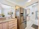 Stainless steel refrigerator in kitchen with light wood cabinets and view into a dining area at 4521 Eaglewood Dr, Leesburg, FL 34748