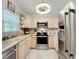Well-lit kitchen featuring stainless steel appliances, light wood cabinets, and neutral countertops at 4521 Eaglewood Dr, Leesburg, FL 34748
