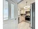 Updated kitchen view through doorway showcasing stainless steel appliances and light wood cabinets at 4521 Eaglewood Dr, Leesburg, FL 34748