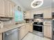 Bright kitchen with stainless steel appliances, neutral counters, tile backsplash, and light wood cabinets at 4521 Eaglewood Dr, Leesburg, FL 34748
