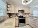 Updated kitchen showcasing stainless steel appliances, light wood cabinets, and neutral countertops at 4521 Eaglewood Dr, Leesburg, FL 34748
