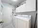 Bright laundry room featuring a washer and dryer and storage cabinets, offering convenience and organization at 4521 Eaglewood Dr, Leesburg, FL 34748