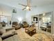 Inviting living room with comfortable seating, ceiling fan, and sliding glass doors to the sunroom at 4521 Eaglewood Dr, Leesburg, FL 34748