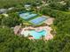 An aerial view of a community pool, basketball court, tennis courts and playground surrounded by mature trees at 4548 Barrister Dr, Clermont, FL 34711