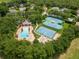 A high angle view of a community pool, basketball court, tennis courts and playground surrounded by trees at 4548 Barrister Dr, Clermont, FL 34711