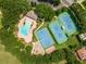 An aerial view of a community pool, basketball court, tennis courts and playground surrounded by trees at 4548 Barrister Dr, Clermont, FL 34711