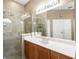 Bright bathroom featuring a glass shower, tan stone floors, and ample vanity space at 4548 Barrister Dr, Clermont, FL 34711