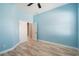 Light blue bedroom featuring a ceiling fan and neutral wood floors at 4548 Barrister Dr, Clermont, FL 34711