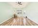 A light-filled bedroom with wood floors, a chair and a ceiling fan at 4548 Barrister Dr, Clermont, FL 34711