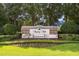 Landscaped Regency Hills community entrance sign on a manicured lawn with flower beds and mature trees at 4548 Barrister Dr, Clermont, FL 34711