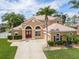 Lovely single-Gathering home with mature landscaping, palm trees, and a well-maintained lawn at 4548 Barrister Dr, Clermont, FL 34711
