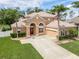 Elevated view showcasing the beautiful home, lush lawn, mature palms, and expansive driveway at 4548 Barrister Dr, Clermont, FL 34711