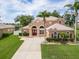 Attractive stucco home boasts mature palm trees, lush lawn, and a grand double-door entrance at 4548 Barrister Dr, Clermont, FL 34711