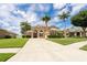 Charming home with stucco exterior, arched windows, well-manicured lawn, and mature palm trees at 4548 Barrister Dr, Clermont, FL 34711