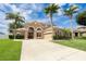 Attractive stucco home boasts mature palm trees, lush lawn, and a grand double-door entrance at 4548 Barrister Dr, Clermont, FL 34711