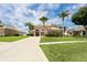 Stately home with lush landscaping, mature palms, and expansive driveway with verdant lawn at 4548 Barrister Dr, Clermont, FL 34711
