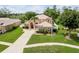 Gorgeous residence featuring a lush green lawn, mature palm trees, and a long driveway at 4548 Barrister Dr, Clermont, FL 34711