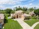 Beautiful home featuring mature palm trees, lush greenery, and a well-manicured lawn at 4548 Barrister Dr, Clermont, FL 34711