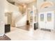Grand foyer features soaring ceilings, a staircase, hardwood floors, and decorative front doors with leaded glass at 4548 Barrister Dr, Clermont, FL 34711