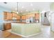 Open-concept kitchen featuring wooden cabinets, granite countertops, and views of the staircase at 4548 Barrister Dr, Clermont, FL 34711