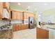 Well-lit kitchen with stainless steel appliances, granite countertops, and wooden cabinetry at 4548 Barrister Dr, Clermont, FL 34711