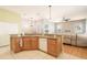 Open kitchen with an island, wooden cabinets, granite countertops, and seamless access to the living area at 4548 Barrister Dr, Clermont, FL 34711