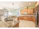 Spacious kitchen with granite countertops, wooden cabinets, stainless steel appliances, and an island sink at 4548 Barrister Dr, Clermont, FL 34711