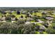 Scenic aerial shot of a residential area featuring homes nestled among mature trees and a golf course at 4904 Long Meadow Dr, Leesburg, FL 34748