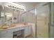 Bathroom featuring double sinks, vanity, large mirror, tiled floor, and a shower at 4904 Long Meadow Dr, Leesburg, FL 34748