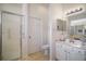 Bathroom featuring a toilet, vanity with sink, large mirror, tiled floor, and a shower at 4904 Long Meadow Dr, Leesburg, FL 34748