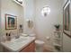 Well-lit powder bathroom features a patterned accent window, decorative plants, and framed artwork at 4904 Long Meadow Dr, Leesburg, FL 34748