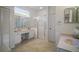 Bathroom featuring double sinks, vanity, large mirror, tiled floor, and a stand-up shower at 4904 Long Meadow Dr, Leesburg, FL 34748