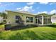 Exterior view of the house featuring well-kept landscaping, multiple windows, and screened porch at 4904 Long Meadow Dr, Leesburg, FL 34748