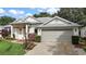 Well-maintained single-story home with a two-car garage, lush landscaping, and a bright exterior at 4904 Long Meadow Dr, Leesburg, FL 34748