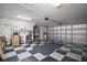 Spacious garage with ample storage shelving and a durable checkered floor pattern at 4904 Long Meadow Dr, Leesburg, FL 34748