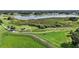 Picturesque aerial view of a lush golf course with ponds and manicured green hills at 4904 Long Meadow Dr, Leesburg, FL 34748